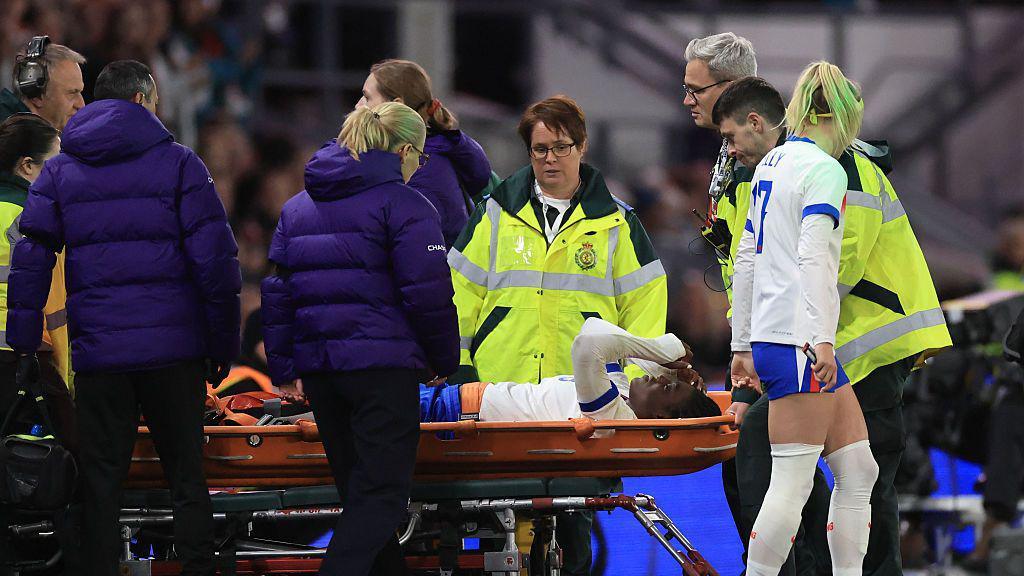Michelle Agyemang being stretchered off the pitch.