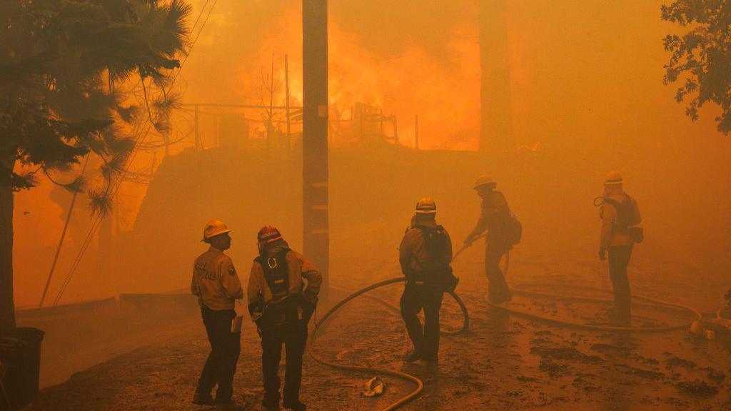  Firefighters can do little to save an engulfed home as the Line fire burns into a tree lined neighborhood on September 10, 2024 in Running Springs, California.