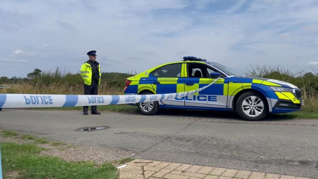 Screen grab taken from PA Video of a police vehicle blocking the road in the village of Stathern, Leicestershire
