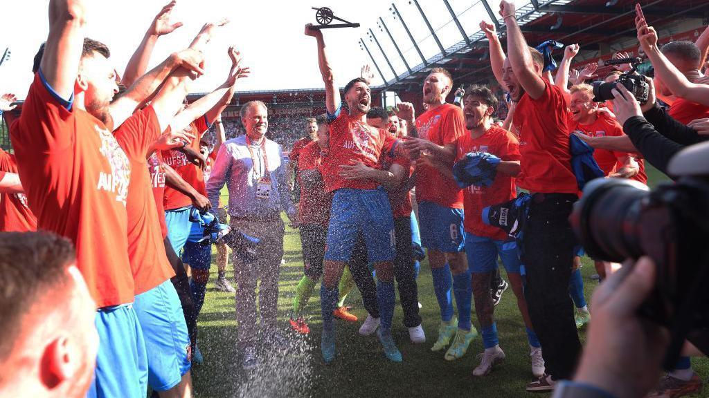 Tim Kleindienst of 1. FC Heidenheim 1846 celebrates with the golden boot award after the team's victory and promotion to the Bundesliga in the Second Bundesliga match between SSV Jahn Regensburg and 1. FC Heidenheim 1846 at Jahnstadion on May 28, 2023 in Regensburg, Germany