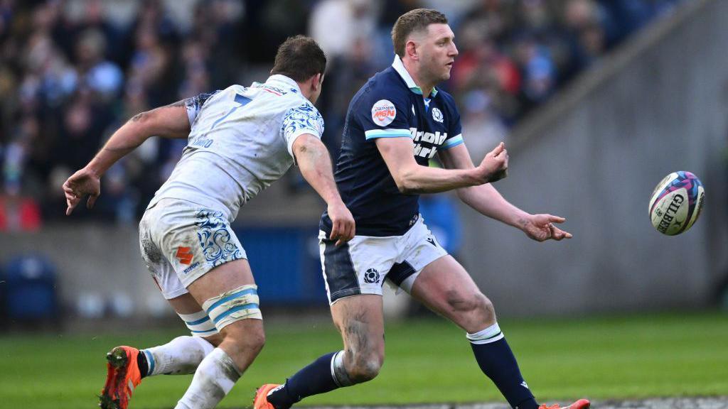 Finn Russell under pressure from Michele Lamaro