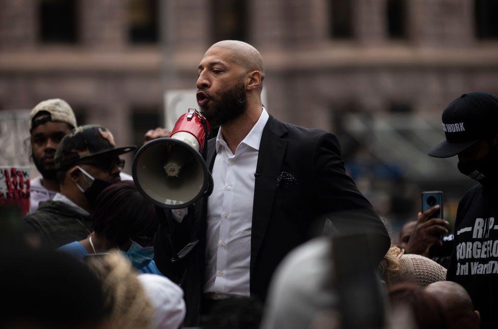 White holds a megaphone in a crowd of people