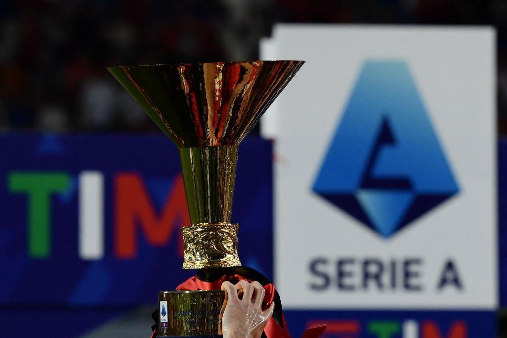 The Scudetto trophy is lifted into the air in front of the Serie A logo by champions AC Milan