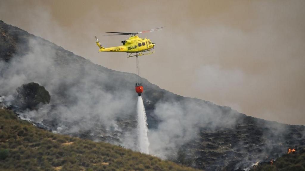 A fire service helicopter drops water onto one of the hotspots of the wildfire that broke out in Los Gallardos, Almeria, Spain, 10 July 2026. 