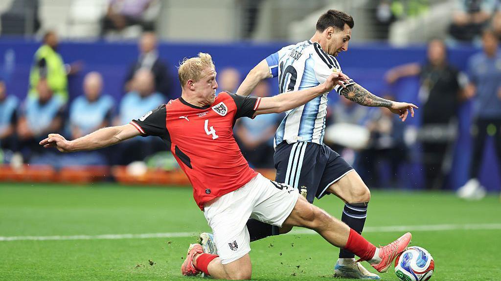 Xaver Schlager slide-tackles Lionel Messi during Austria's World Cup game against Argentina