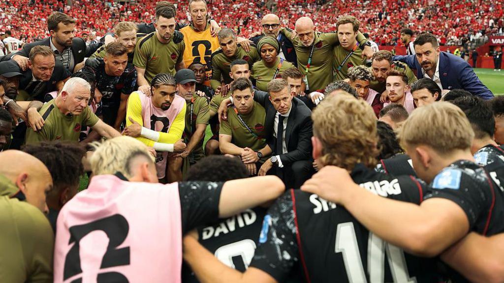 Jesse Marsch with his Canada players gather in a team huddle