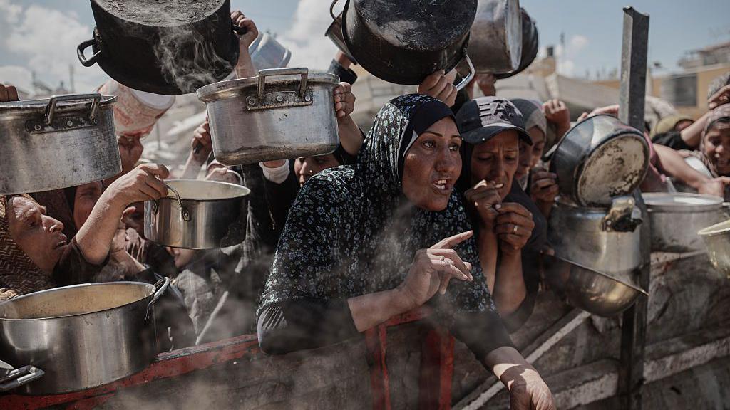 Palestinians, who face difficulties accessing food due to the blockade imposed by Israel, wait to receive hot meals in Gaza Strip on August 5, 2025. 