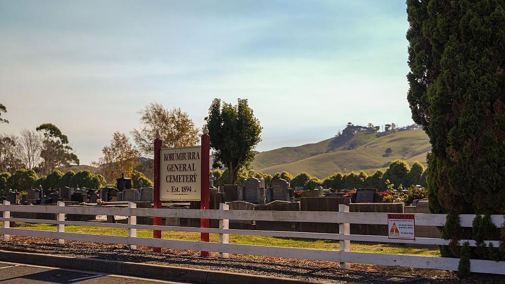 A general view of the Korumburra general cemetery, with trees and rolling hills in the background