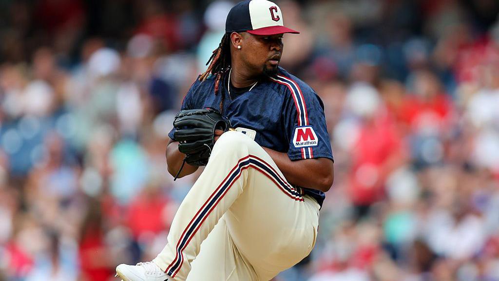 Ortiz about to deliver a pitch during a game, with his body curled up before pitching the ball