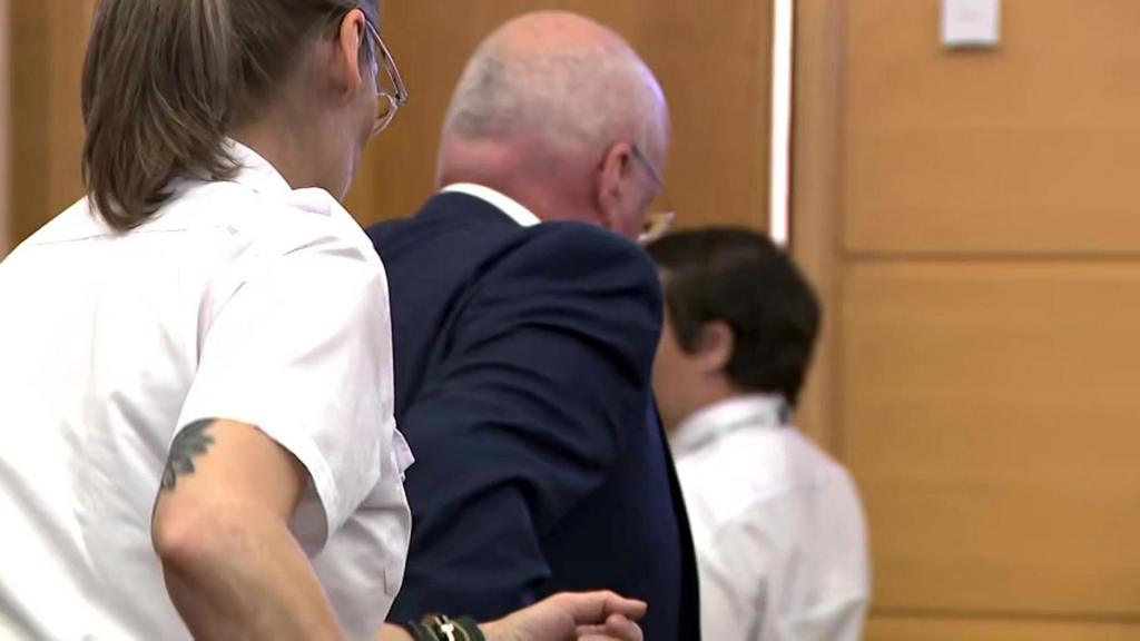 Peter Murrell being led out of court by officers