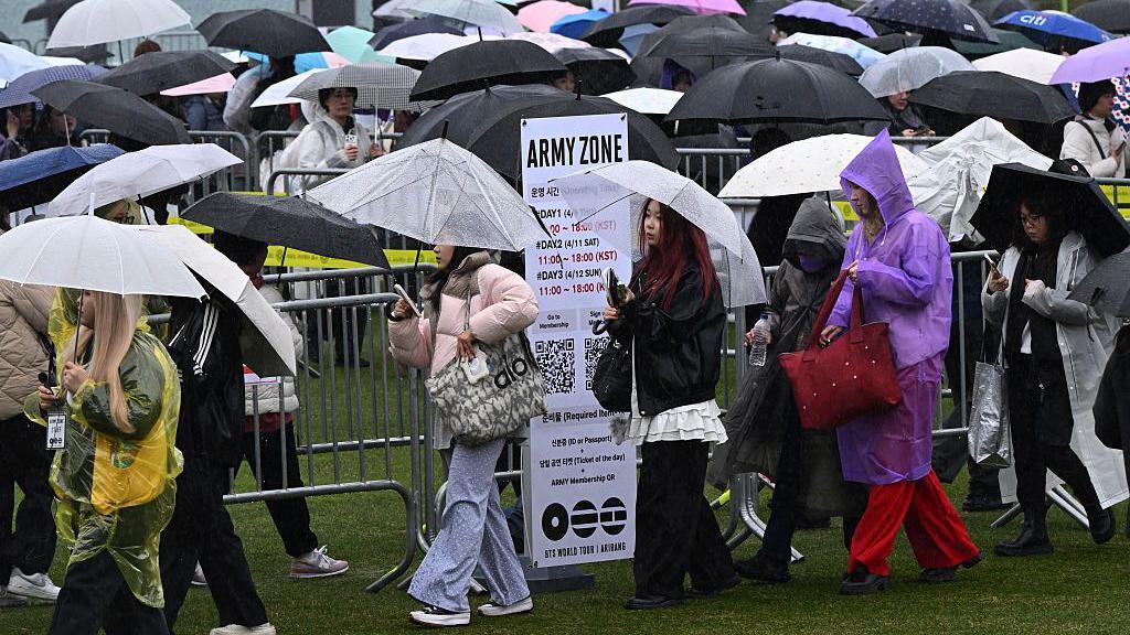 lots of BTS fans queueing with umbrellas to get into Goyang stadium to watch the BTS concert