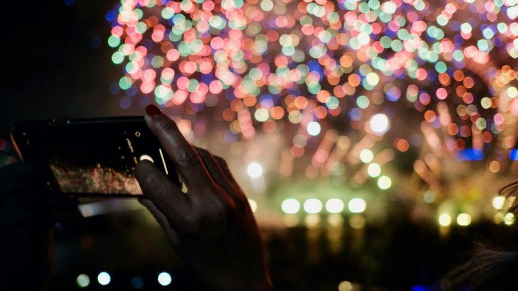 Person takes photo of fireworks on phone 