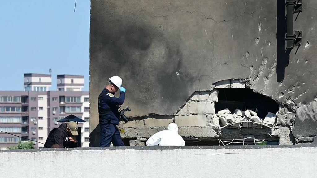 Police and forensic investigators examine the location of impact after a Russian drone struck an apartment building in Galati, eastern Romania. 