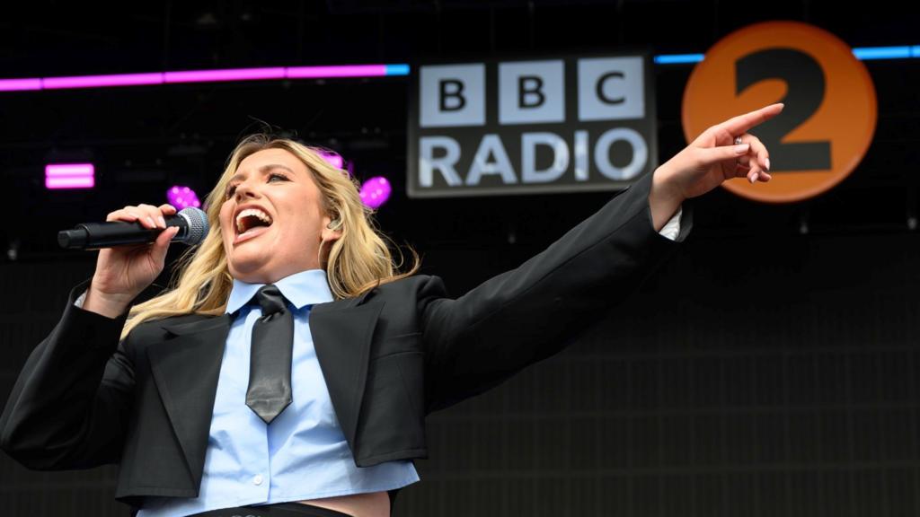 Ella Henderson on stage with a BBC Radio 2 logo behind her.