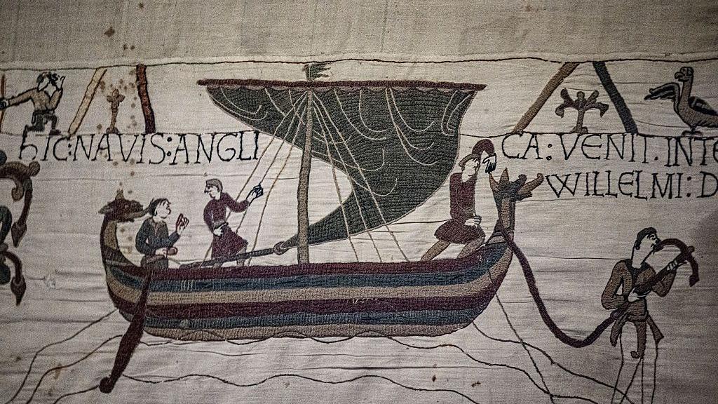 A detail of the Bayeux Tapestry showing a boat with people arriving onto shore 