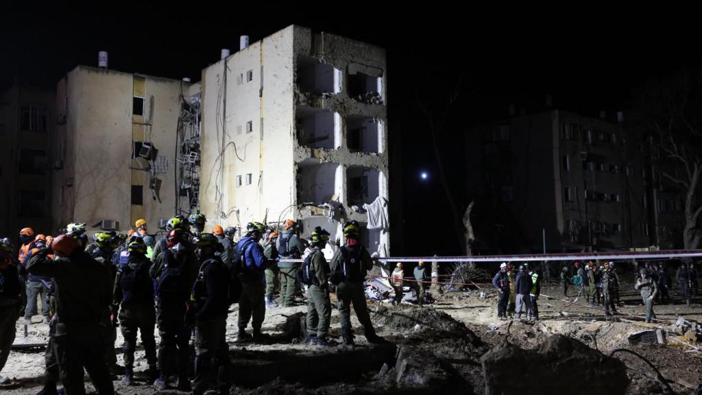 Israeli security, rescue, and paramedics work at the scene of a direct hit of an Iranian missile in Arad.