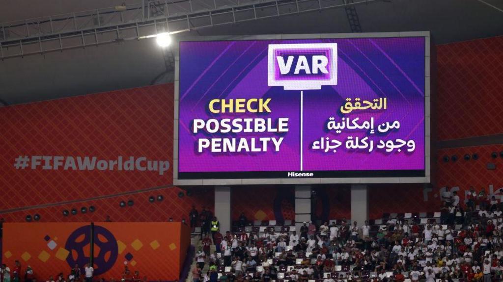 A screen inside the stadium displays the decision to check VAR for a penalty during 2022 Fifa World Cup.