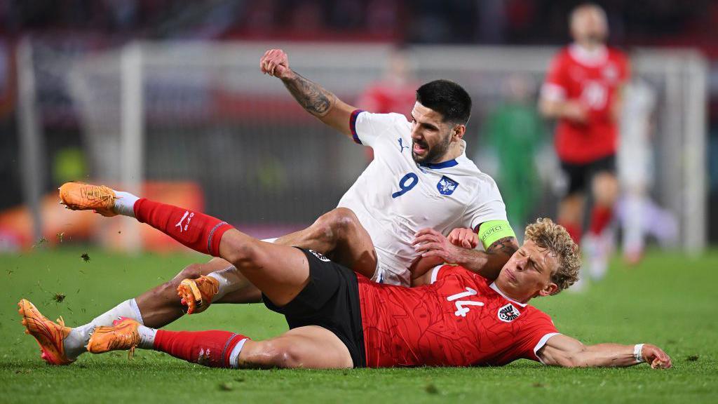 Leopold Querfeld tackles Serbia striker Aleksandar Mitrovic