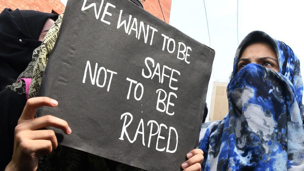 TOPSHOT - A Kashmiri demonstrator holds a placard during a protest calling for justice following the recent rape and murder case of an eight-year-old girl in the Indian state of Jammu and Kashmir, in Srinagar on April 16, 2018. - Eight men accused of raping and murdering an eight-year-old girl pleaded not guilty April 16 to the horrific crime that has sparked revulsion and brought thousands to India's streets in protest. (Photo by TAUSEEF MUSTAFA / AFP) (Photo by TAUSEEF MUSTAFA/AFP via Getty Images)