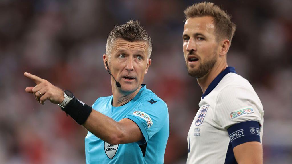 Harry Kane talks with a referee