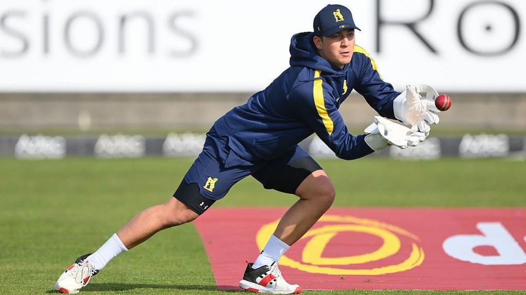 Warwickshire wicketkeeper Kai Smith moves to his left to take a catch during fielding practice in a pre-match warm-up