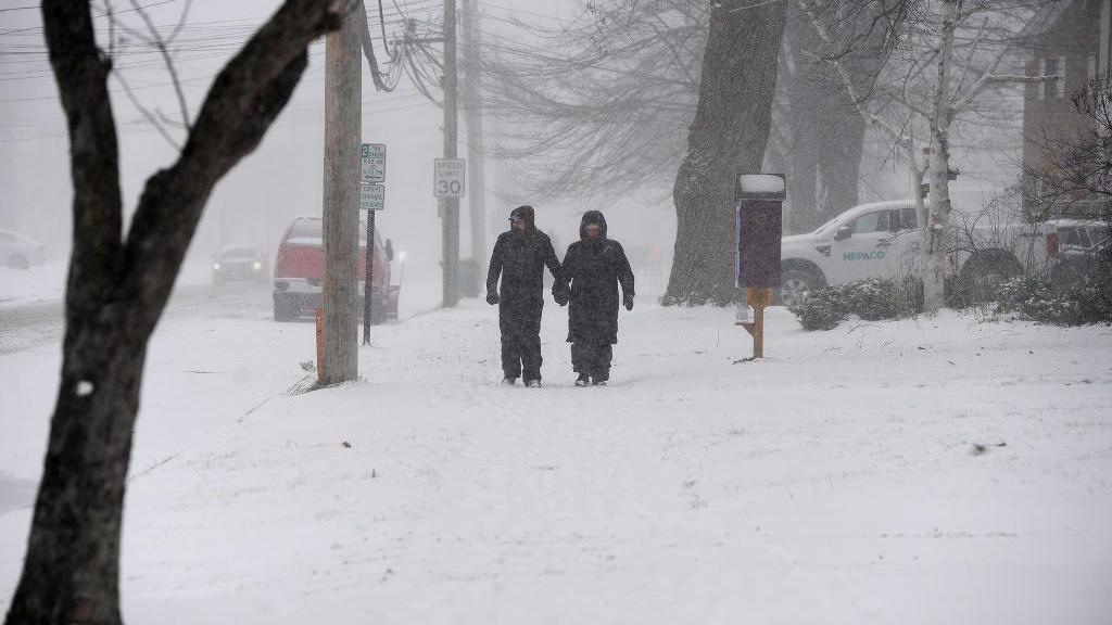 A couple makes their way through lake effect snow to attend the annual Hamburg Holiday Parade on November 30, 2024 in Hamburg, New York