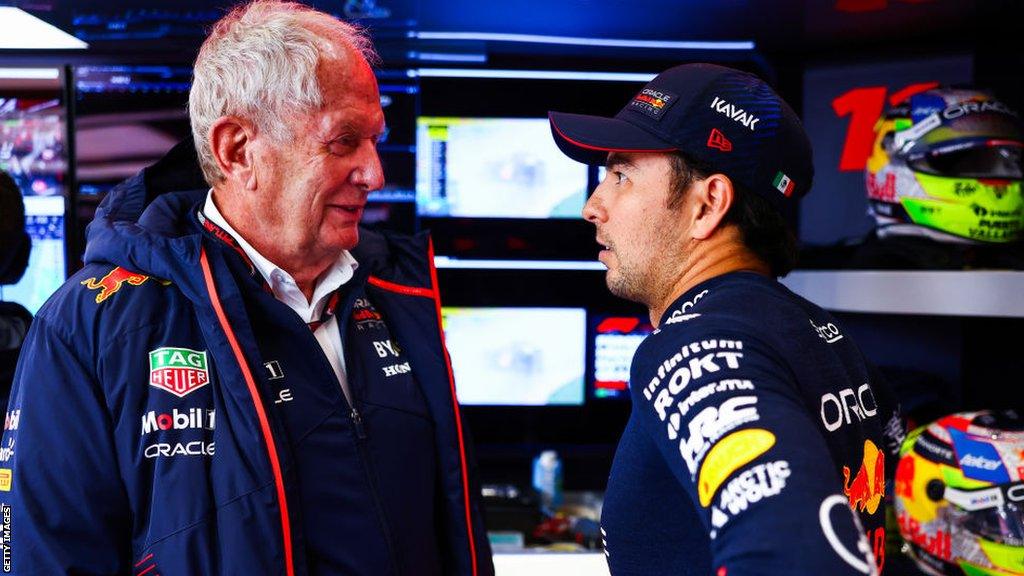 Helmut Marko chats to Sergio Perez in the Red Bull garage