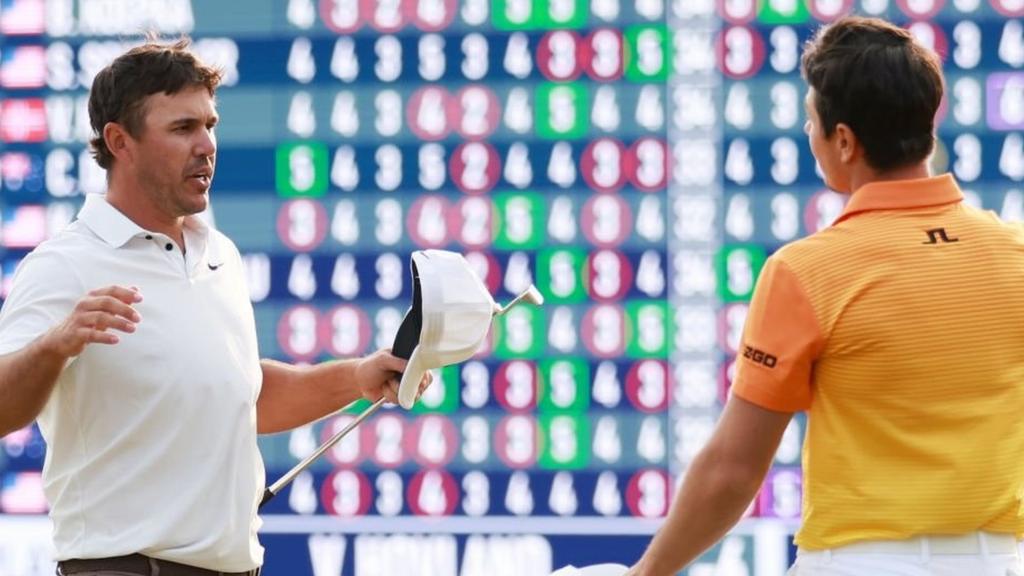 Brooks Koepka and Viktor Hovland on the 18th green at Oak Hill