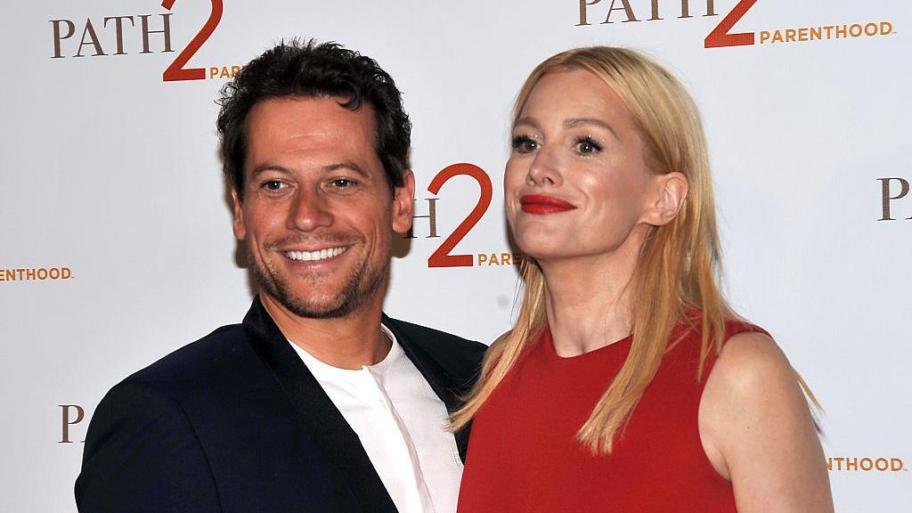 Gruffudd and Evans smiling at the Path 2 Parenthood Annual Gala red carpet in Los Angeles on April 15, 2016. Gruffudd, on the left, wears a black suit and white shirt. Evans wears a red dress and has blonde hair.