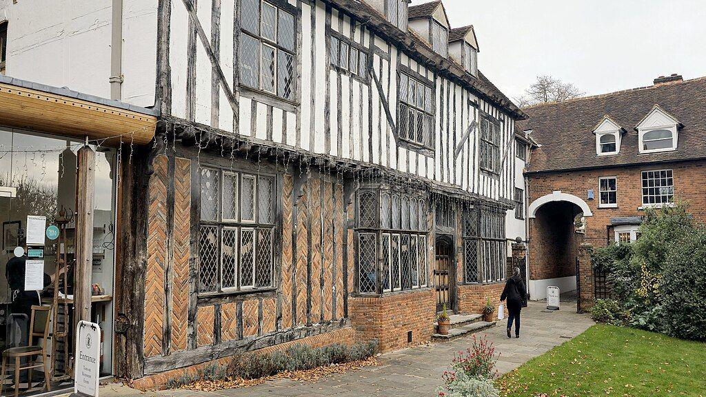 The frontage of Tymperleys, a 15th Century building in Colchester city centre. It is a half white, half brick building with black wooden beams.