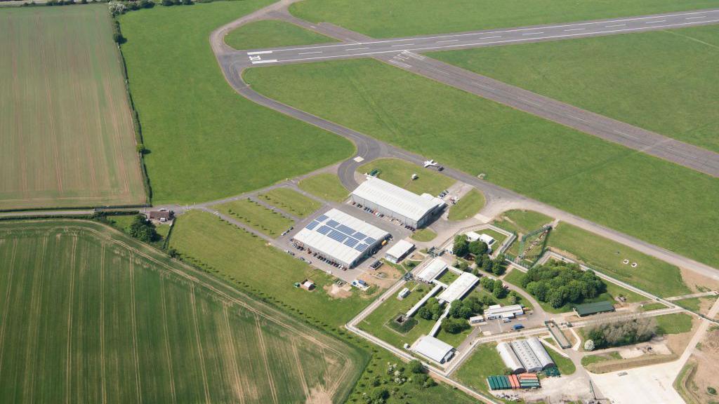 A bird's eye view of Chalgrove Airfield in Oxfordshire, with buildings and a runway running to the left of the picture to the top-right corner