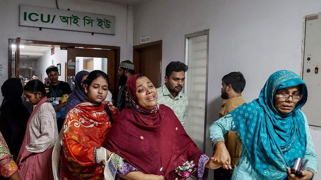 The mother (C) of an injured student weeps inside a hospital after an Air Force training jet crashed into a school in Dhaka on July 21, 2025