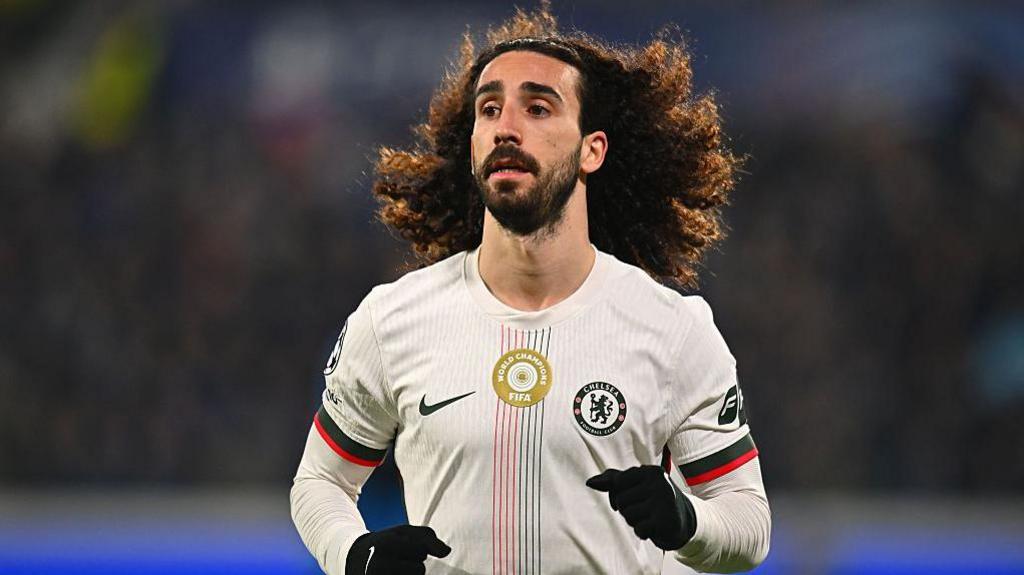 Marc Cucurella running in a sponsorless white Chelsea away shirt