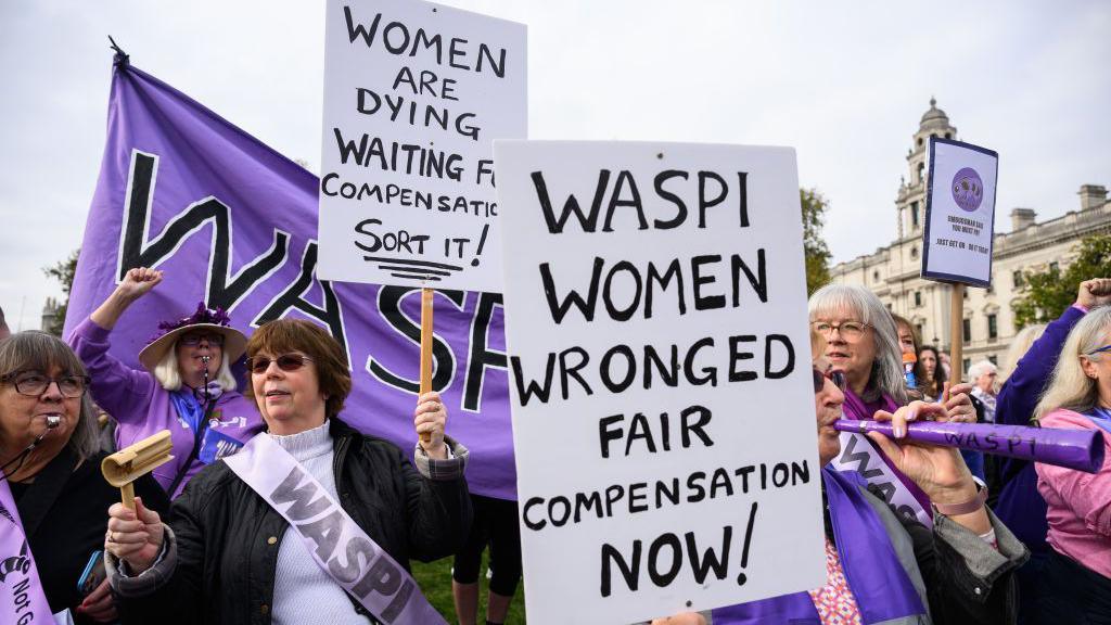 Protesters from the Women Against State Pension Inequality (Waspi) group demonstrate outside Parliament in London. They are wearing purple sashes and holding signs reading: "Waspi women wronged, fair compensation now!" and "Women are dying waiting for compensation - sort it!"