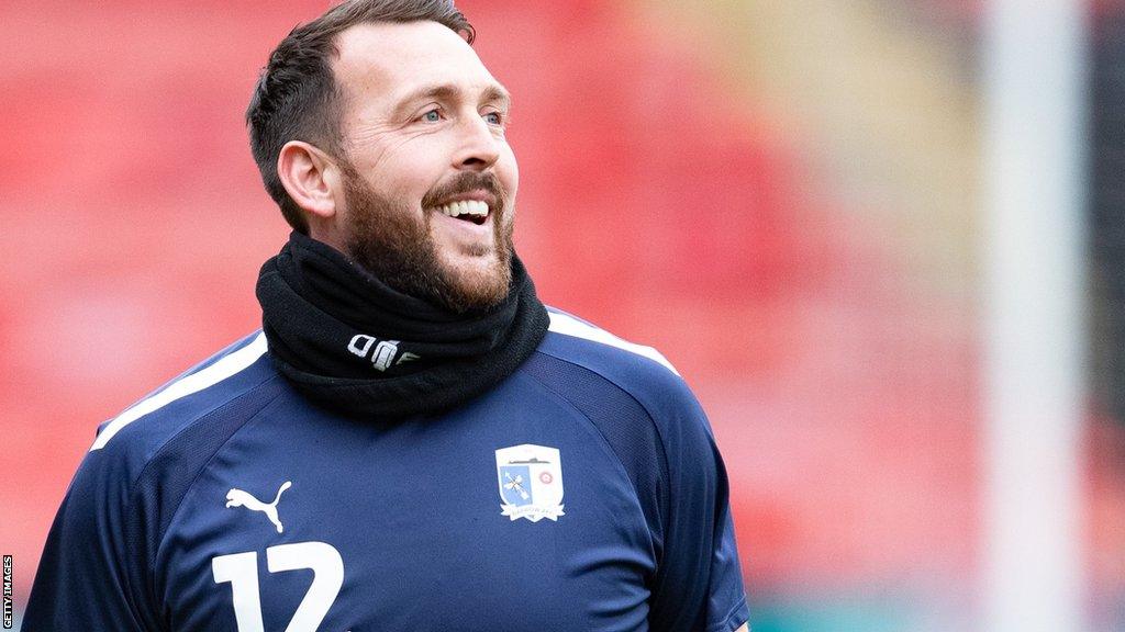 Josh Lillis smiles as he warms up for Barrow before a game at Walsall