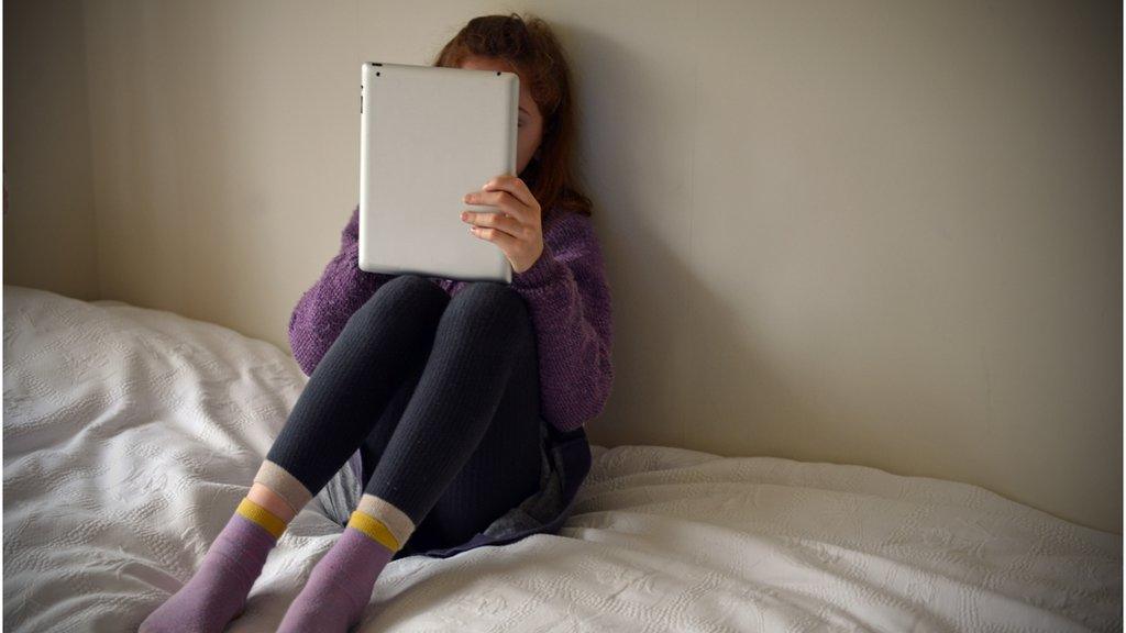 Child on bed with laptop