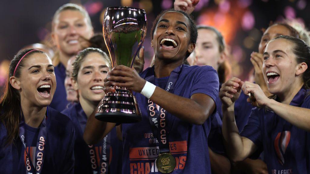 Naomi Girma lifting the 2024 Concacaf W Gold Cup trophy.