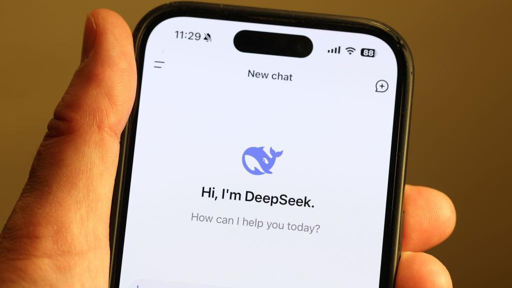 Hand holding smartphone, showing DeepSeek logo 