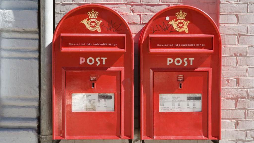 two red post boxes on a wall in Copenhagen, Denmark.