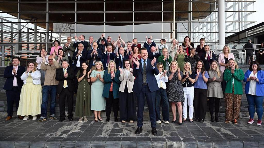 Rhun ap Iorwerth in front of the Senedd with Plaid Cymru MSs behind him
