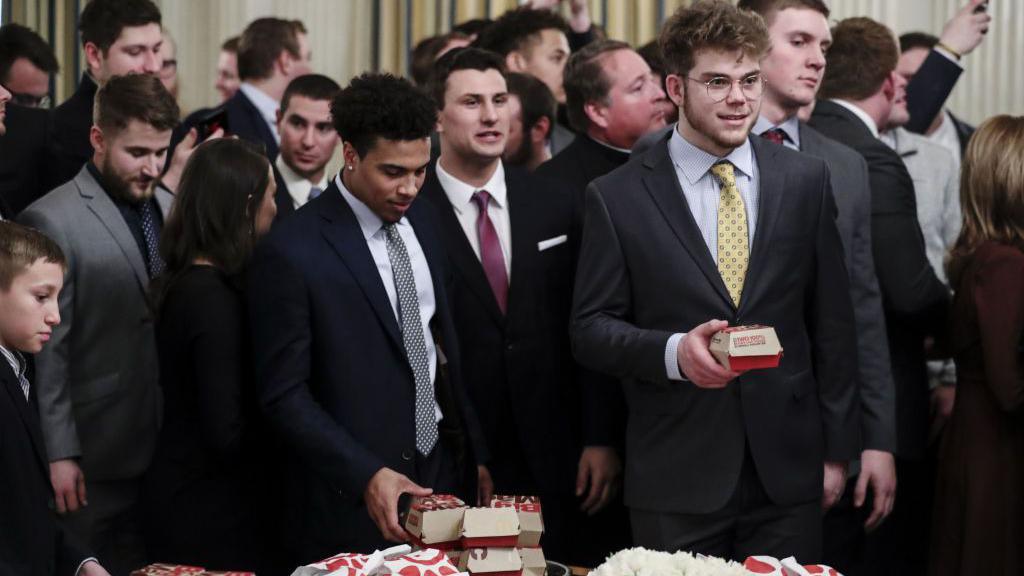 2018 Division 1 Football National Champions, North Dakota State Bison, players take food from a table of McDonald's Corp. Big Mac hamburgers and Chick fil-A Inc. sandwiches as U.S. President Donald Trump, not pictured, welcomes the team at the White House in Washington, DC