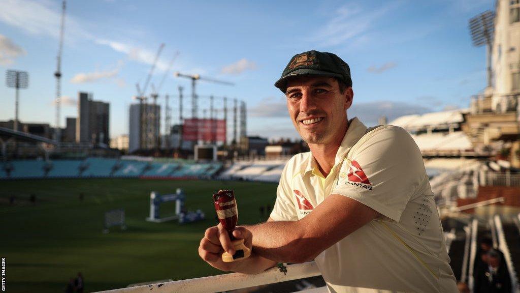 Australia captain Pat Cummins smiles as he holds the Ashes urn