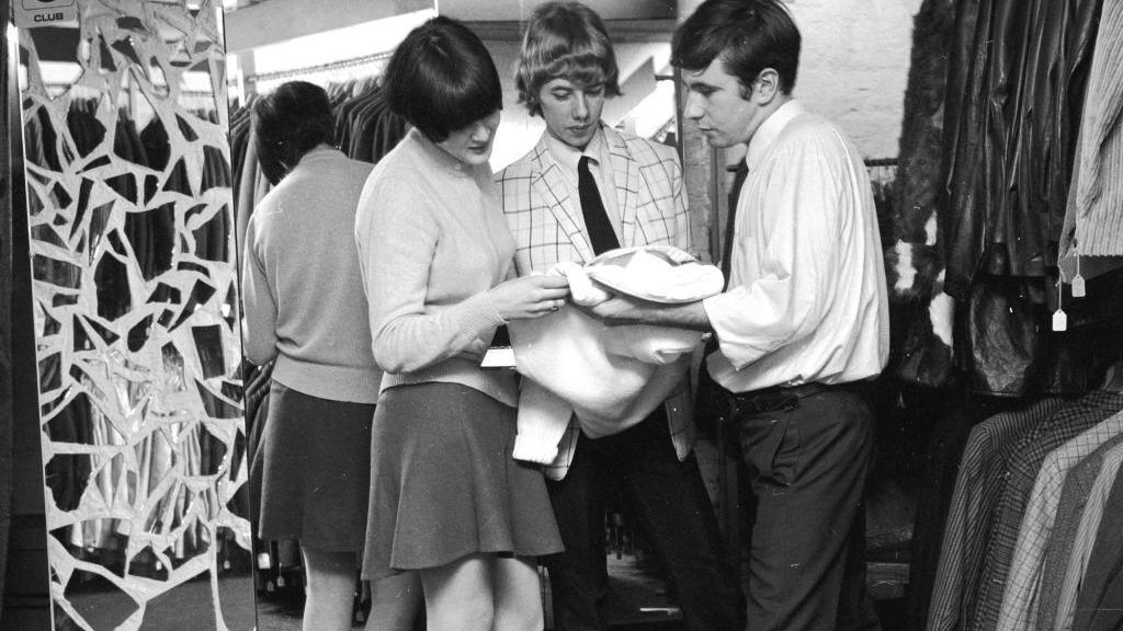A young couple shopping for clothes at Mates boutique in Carnaby Street, London.