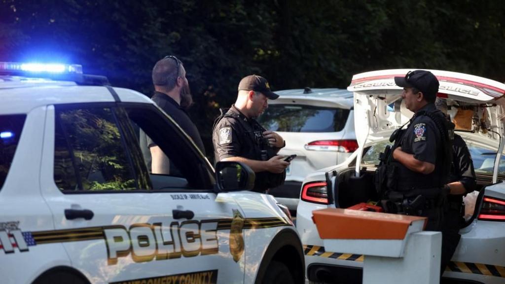 Police stand outside the home of former national security adviser John Bolton