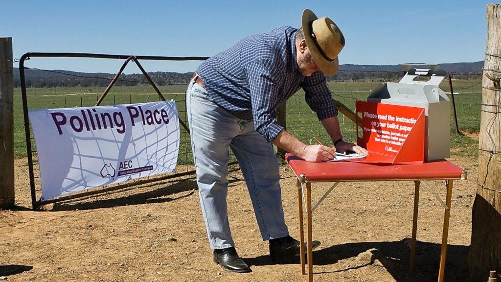 Man voting on a small table outside on a farm