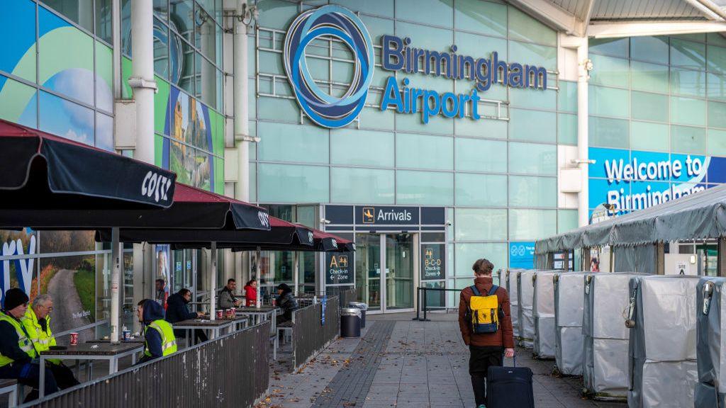 An airline passenger arrives at Birmingham Airport Ltd. in Birmingham, UK, on Thursday, Dec. 21, 2023