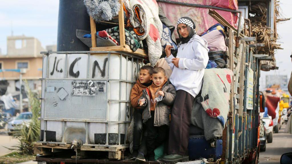 Displaced Palestinians continue to wait with their belongings at a point close to the Netzarim Corridor