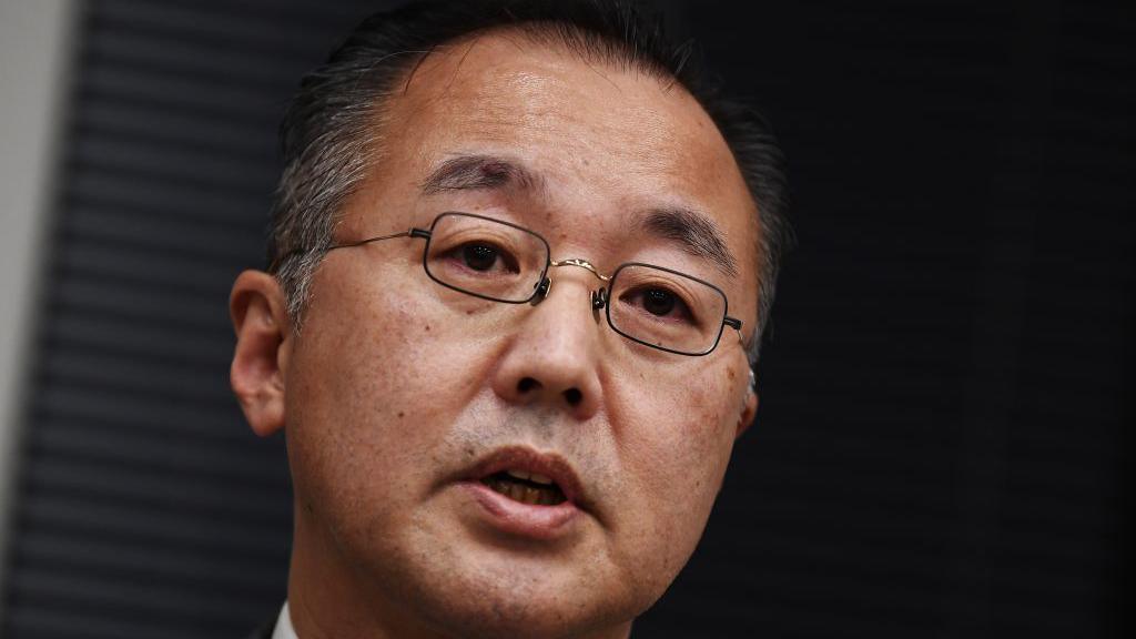 Noriyuki Yamaguchi - a man in square-shaped glasses, with dark hair which is greying at the temples - pictured at a press conference in Tokyo on 18 December, 2019.