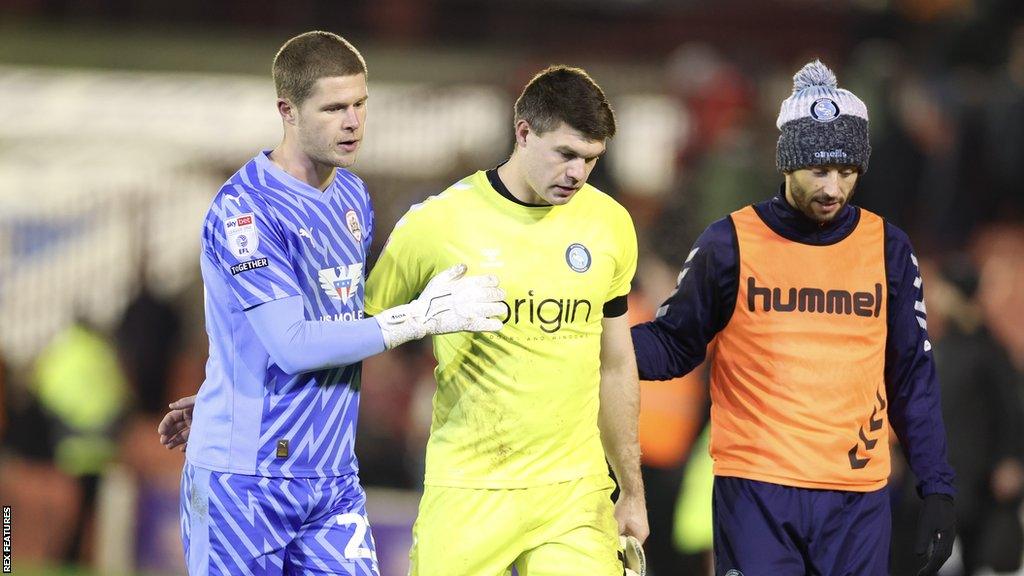 Wycombe goalkeeper Max Stryjek walking off the pitch at full time