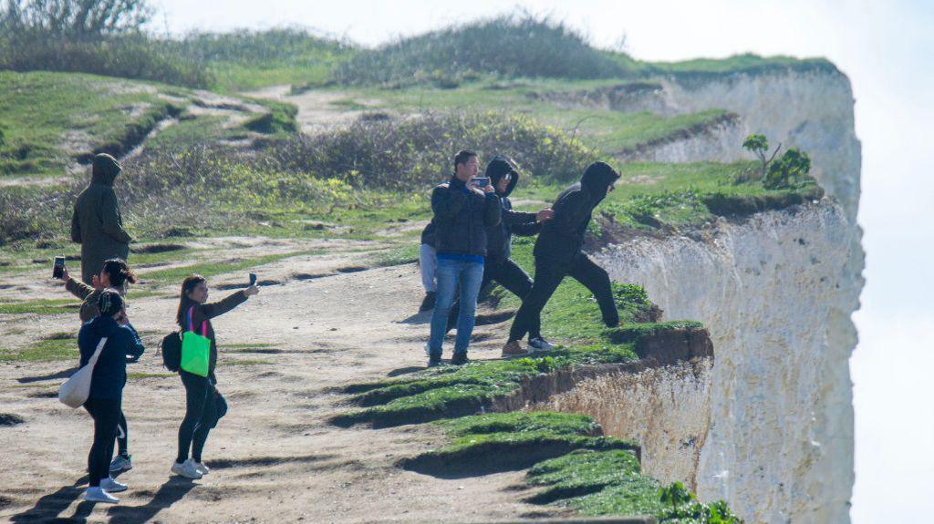 People at Birling Gap cliff edge 